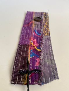 a piece of fabric with scissors on top of it and some thread in the middle