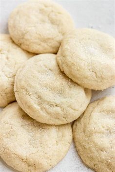 a pile of sugar cookies sitting on top of a white tablecloth covered in powdered sugar