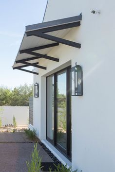 a white house with black trim and an awning