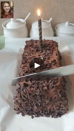 a cake with chocolate frosting and a lit candle