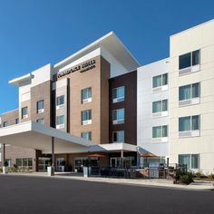 a large hotel building with cars parked in front