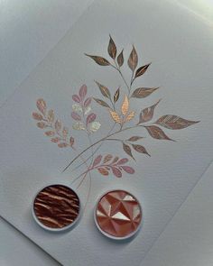 two pieces of paper on top of each other with gold foiling and leaf designs