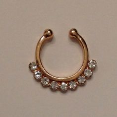 a gold nose ring with small crystal stones