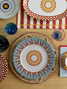 a table topped with plates and bowls filled with different colored dishes next to each other