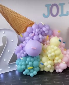 an ice cream cone is on top of balloons in front of the number twenty two