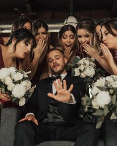 a group of bridesmaids and groomsmid posing for a photo with their hands in the air