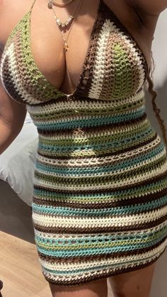 a woman in a crocheted dress is taking a selfie