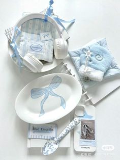 a white table topped with blue items on top of a plate next to a baby blanket