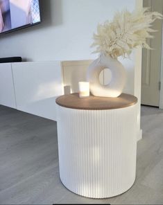 a white vase with some flowers on top of it