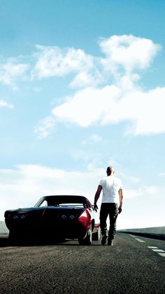 a man standing next to a car on the road