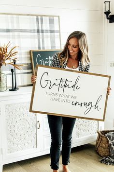 a woman holding a sign that says grateful turns what we have to say in it