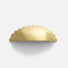 a gold plate with scalloped edges on a white background