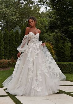 a woman in a wedding dress standing on a stone walkway