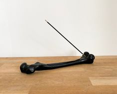 a wooden table with a black object on it and a stick sticking out of it