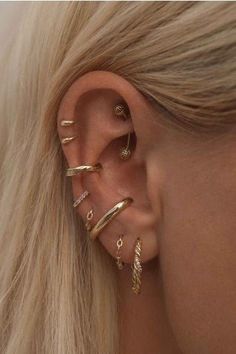 a woman's ear with three different types of piercings