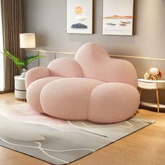 a pink couch sitting on top of a wooden floor next to a white table and chair