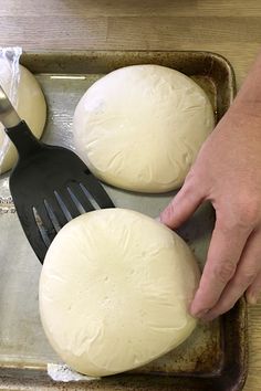 a person using a spatula to spread dough on top of each other in a pan