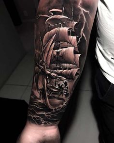 a man's arm with a ship on it and storm clouds in the background