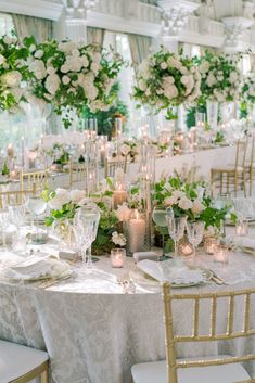 the tables are set with white flowers and candles