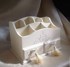 a white jewelry box with tassels on it