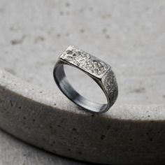 This stylish Men's Signet Ring is handmade by our expert jewellers in the heart of Brighton. Cast from solid sterling silver and due to the process our jewellers use, each ring is unique, much like 'molten'. The ring features a textured oxidised sterling silver rectangle bezel. Each ring is handmade by our skilled artisan jewellers in our Brighton workshop. The bezel of the signet ring measures 1. 3cm across. Ring width 5. 5mm. Please specify your ring size (this is the standard UK letter ring size). Handmade in oxidised 925 sterling silver Handmade in oxidised 925 sterling silver. Each item is individually handmade to order in our Brighton workshop. All of our items are handmade so please check that all personalisation, sizing, product options and delivery information have been entered co Men Signet Ring, Russian Ring, Posh Totty, 6 Characters, Handmade Gifts For Men, Signet Ring Men, Letter Ring, Silver Signet Ring, Birthday Ring