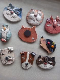 there are many small ceramic cats and dogs on the table together, including one with a cat's head