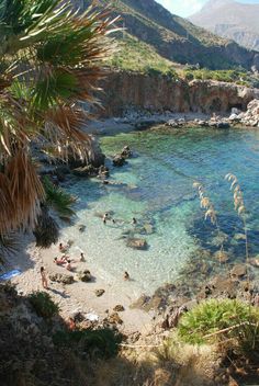 people are swimming in the clear blue water