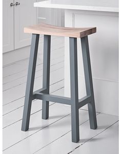 a wooden stool sitting on top of a white counter