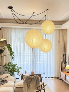 a living room filled with furniture and hanging lights