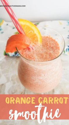 an orange carrot smoothie in a glass with straws and garnishes