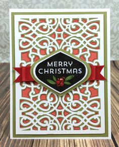 a christmas card with the words merry christmas written in black and red, on a wooden surface