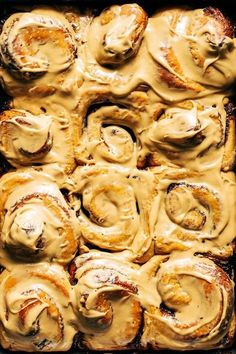 a pan filled with cinnamon rolls covered in icing