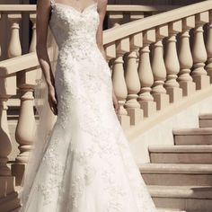 a woman in a wedding dress standing on stairs