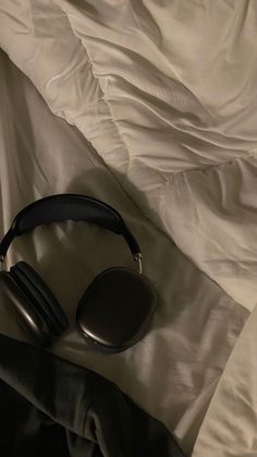 a pair of headphones laying on top of a bed