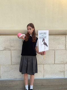 a girl holding a sign and a pink ball