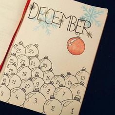 an open notebook with a drawing of a christmas ornament and the words december on it