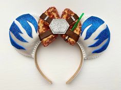 a mickey mouse ears headband with an orange, blue and white bow on it