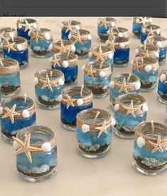 small glass jars filled with sand and starfish