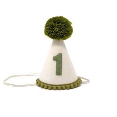 a green and white hat with the number one on it's top, sitting on a string