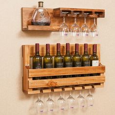 wine glasses and bottles are sitting on the shelf next to each other in front of a wall mounted wine glass rack