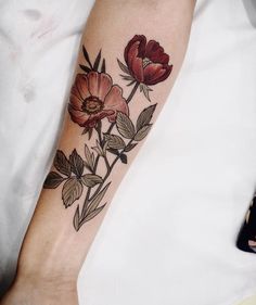 a woman's arm with flowers and leaves on the left side of her body