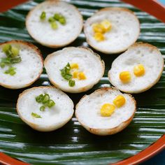 small appetizers are arranged on a green leafy platter, ready to be eaten