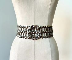 1960s mod adjustable statement belt in silver metal with a stunning circular buckle. The belt is adjustable up to 31". The belt is in excellent condition with two metal hooks on the back side of the buckle closure for an adjustable fit. An incredibly special piece to add to your wardrobe to dress up any look from a silk slip dress to cinching a jumpsuit or evening gown, this gorgeous belt is a real treasure! 31.5" long by 2.5" wide and 2.75" at buckle. Please message with any questions. Modern Silver Belt For Formal Occasion, Elegant Silver Belt Buckles With Removable Belt, Chic Silver Belts For Formal Occasions, Chic Silver Metal Chain Belt, Luxury Silver Metal Chain Belt, Vintage Adjustable Metal Belt, Modern Adjustable Silver Belt Buckles, Modern Silver Adjustable Belt Buckles, Luxury Adjustable Silver Belt Buckles