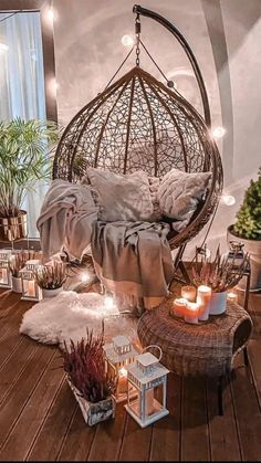 a room filled with lots of plants and candles on top of a wooden floor next to a window