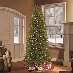 a christmas tree in a living room decorated for the holiday season with lights and presents