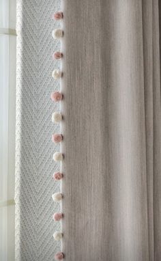 a curtain with pom - poms hanging from it's side