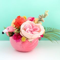 a pink vase filled with flowers on top of a table