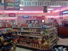 the inside of a grocery store filled with food and drink items, including sodas