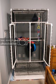 a toy car is in the back of a caged area with toys hanging from it