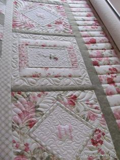 a quilted table runner with pink flowers on it